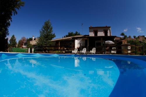 Una gran piscina azul frente a una casa en CASA VENECIA, en Galaroza