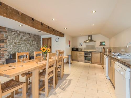 a large kitchen with a wooden table and chairs at Glebe Barn in Caynham