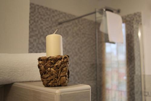 a candle sitting on a table next to a bed at Residenza Bibiena in Mantova