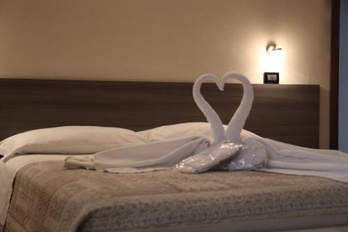 a pair of swans making a heart on a bed at Residenza Bibiena in Mantova