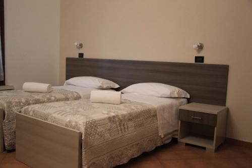 a bedroom with two beds and a wooden headboard at Residenza Bibiena in Mantova
