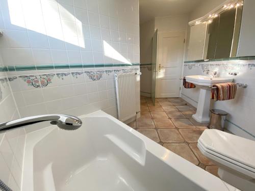a bathroom with a tub and a toilet and a sink at Villa Caprivi - 12 in Heringsdorf