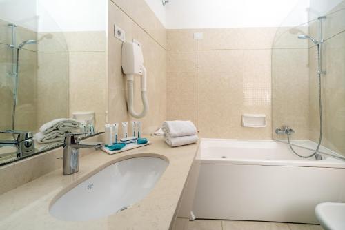 a bathroom with a sink and a tub and a shower at Hotel & Spa Bellavista Francischiello in Massa Lubrense