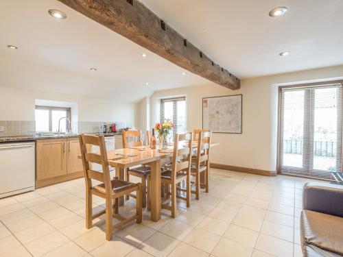 a kitchen and dining room with a wooden table and chairs at Glebe Barn in Caynham