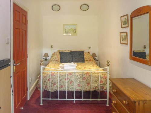 Schlafzimmer mit einem Bett, einer Kommode und einem Spiegel in der Unterkunft 3 Primitive Mews in Chelmorton