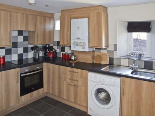 a kitchen with a washing machine and a sink at New Cottage Farm in Flash