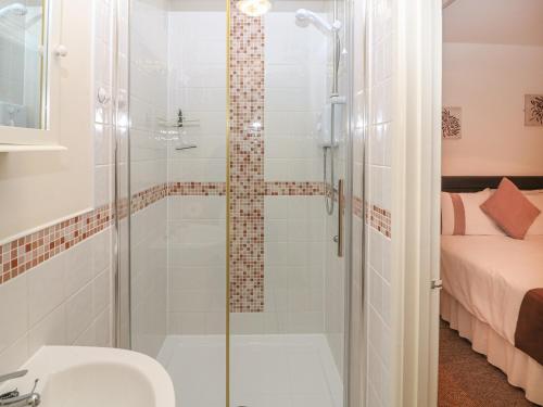 a bathroom with a shower with a toilet and a sink at Peardrop Cottage in Saltfleetby Saint Peter