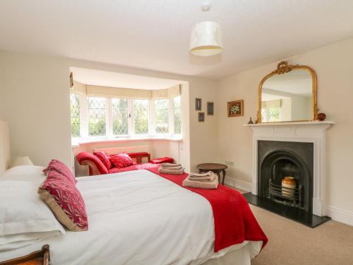 a bedroom with a large bed and a fireplace at Gun End Cottage in Rushton Spencer