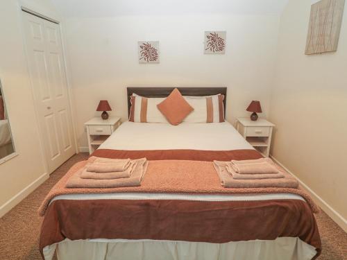 a bedroom with a large bed with two night stands at Peardrop Cottage in Saltfleetby Saint Peter