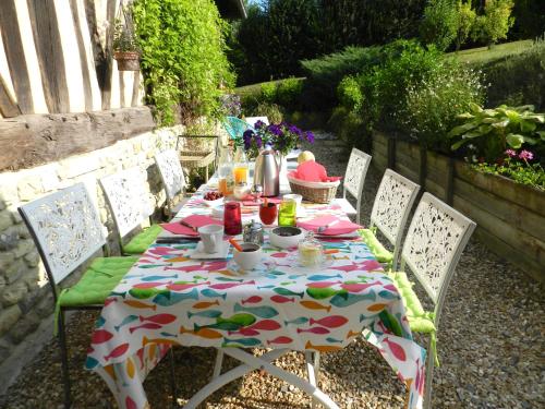 a table with a tablecloth on it with chairs at Le Pressoir in Beuvron-en-Auge