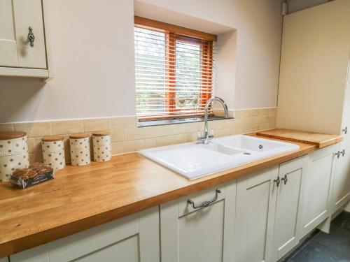a kitchen counter with a sink and a window at Barn Owl Cottage At Crook Hall Farm in Mawdesley
