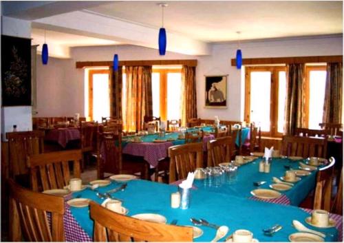 a large dining room with blue tables and chairs at Hotel Ladakh Heaven in Leh