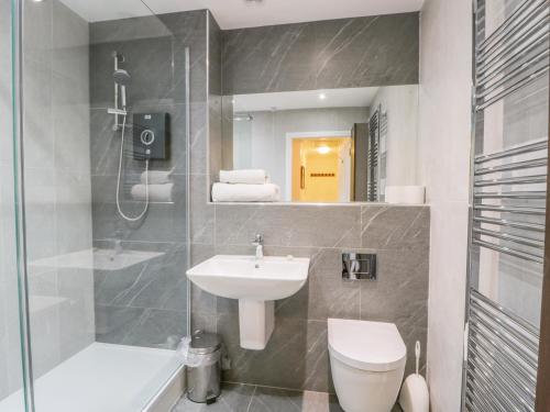a bathroom with a sink and a toilet and a mirror at Whitby Harbour Retreat in Whitby