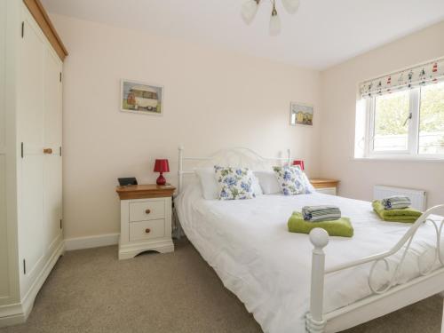 um quarto com uma cama branca e uma janela em Sandlings em Hollesley