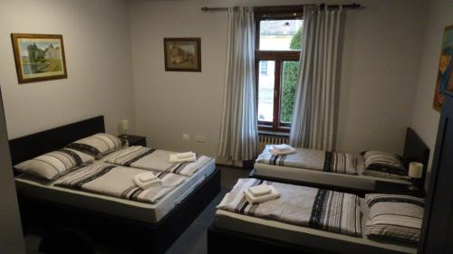 um quarto com três camas e uma janela em Business Club em Slatina