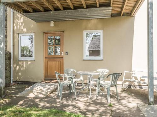 a patio with a table and chairs and a door at The Schoolhouse Bakehouse in Bishops Castle