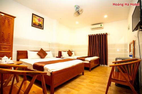 a hotel room with two beds and a table at Hoàng Hà Hotel in Tuy Hoa
