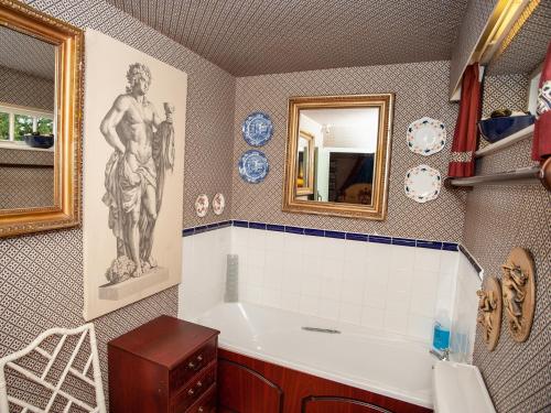 a bathroom with a bath tub and a mirror at Dorrington Court in Dorrington