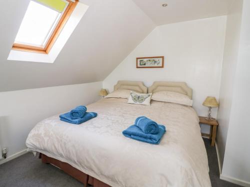 a bedroom with a bed with blue towels on it at The Stilehouse Apartment in Pensax