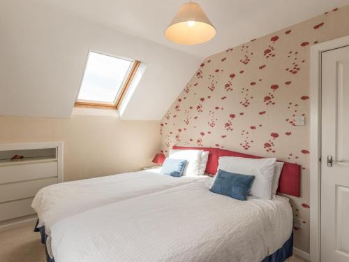 una camera da letto con un grande letto bianco con cuscini rossi di Southview a Coreley