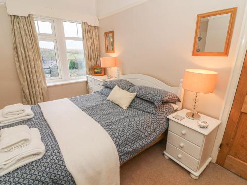um quarto com uma cama e uma janela em Fellside em Appletreewick