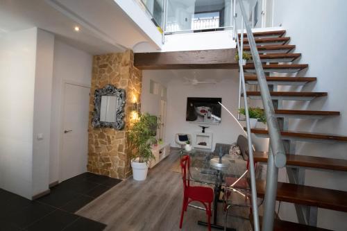 ein Wohnzimmer mit einer Treppe und einem Tisch in der Unterkunft Casa ilhana A in Altea