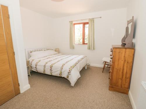 a bedroom with a bed and a television in it at Cwt Blawd in Llangoed
