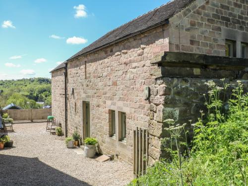 an old brick building with plants in front of it at The Milk House in Wirksworth
