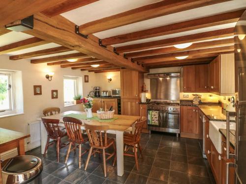 a kitchen with a wooden table and chairs in it at The Milk House in Wirksworth