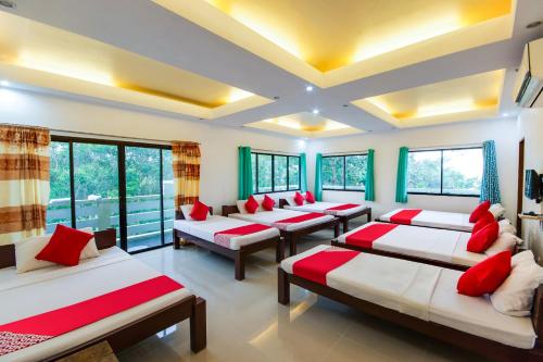 a room with several beds with red pillows at OYO 435 La Veranda Beach Resort in Panglao