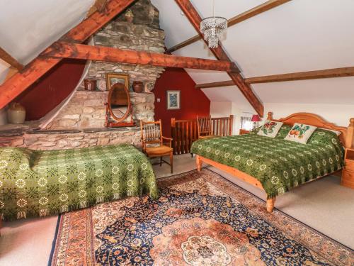 セント・デイビッズにあるGwryd Bach Farmhouseのベッドルーム(ベッド2台、石造りの暖炉付)