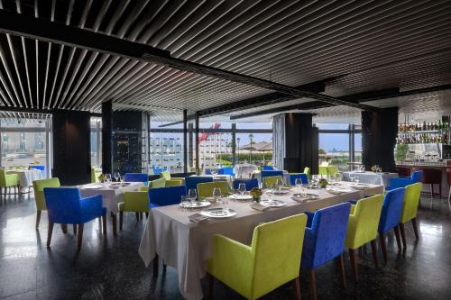 a dining room with white tables and blue chairs at Marco Polo Hongkong Hotel in Hong Kong