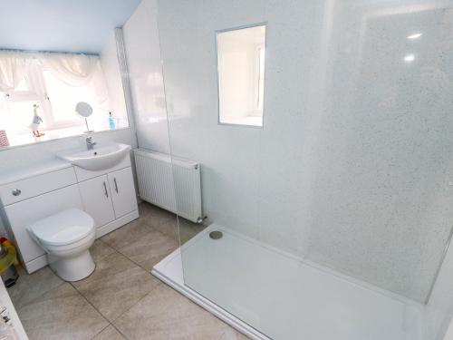 Baño blanco con aseo y lavamanos en Broadhay en Hathersage