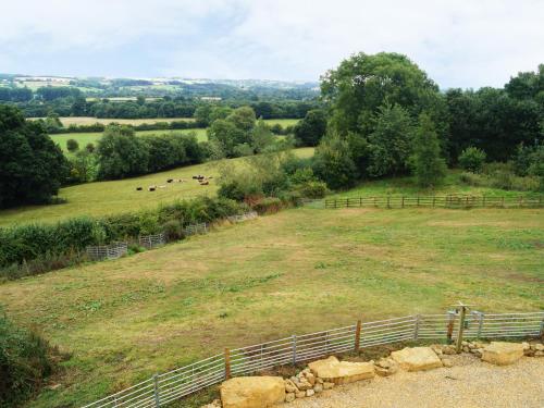 a field with a fence and animals in the distance at Beautiful Cotswold View in Bourton on the Water