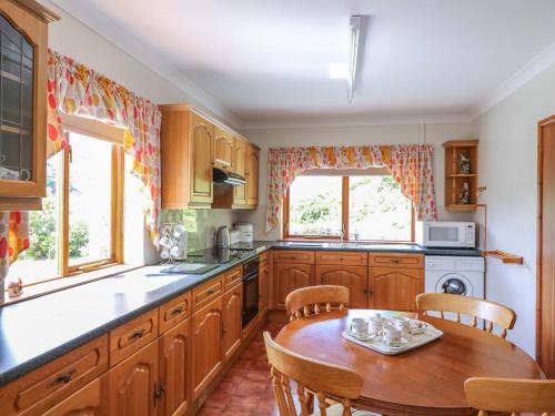 a kitchen with wooden cabinets and a table with chairs at Drainbyrion Farm House in Van