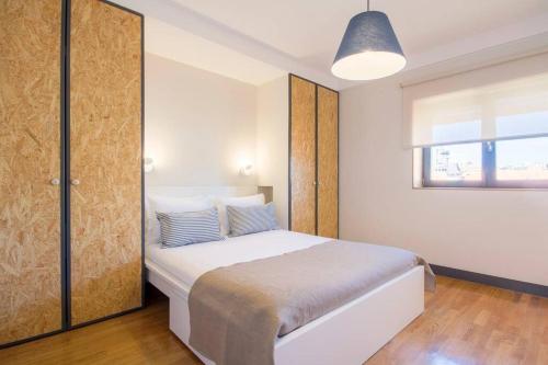 1 dormitorio con cama blanca y ventana en Santa Catarina Roof Top, en Oporto