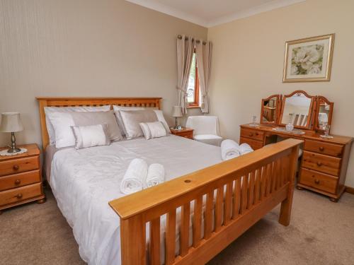 a bedroom with a large bed with a wooden frame at Drainbyrion Farm House in Van