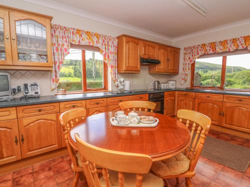 a kitchen with wooden cabinets and a wooden table and chairs at Drainbyrion Farm House in Van