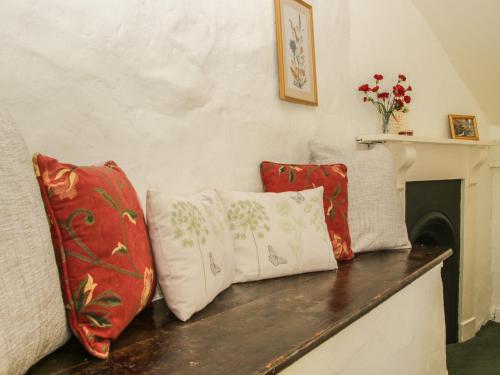 four pillows sitting on top of a wooden bench at Penymaes in Chirk