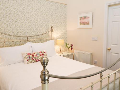 a bedroom with a white bed with a pillow on it at Old Queen's Head in Wolsingham