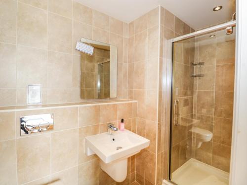 un baño con lavabo y ducha en Eden Lodge, en Bardsea