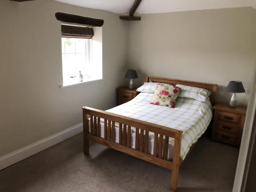 um quarto com uma cama de madeira e uma janela em Carleton Mill with open views to River Eden on the outskirts of Carlisle & 20 mins to Ullswater em Carlisle
