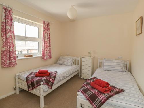 2 camas individuales en un dormitorio con ventana en The Wesley Apartment, en Wells