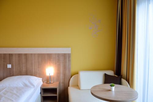 a bedroom with a bed and a table with a chair at Hotel Römerhof in Tulln