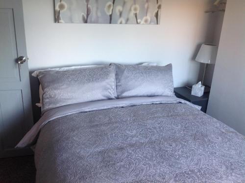 a bedroom with a bed with gray sheets and pillows at BED AT BOWBRIDGE, Centre town in Newark upon Trent