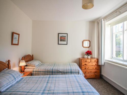 a bedroom with two twin beds and a window at Pensychnant Cottage in Conwy