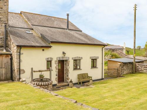 a white cottage with a grass yard in front of it at Higher Whiddon Farm Whiddon Well in Ashburton