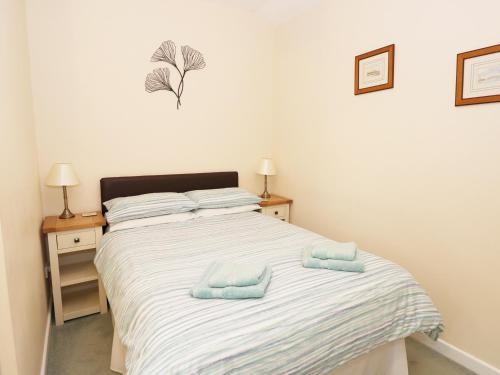 a bedroom with a bed with two towels on it at The Hideaway at The Barn in Tavernspite