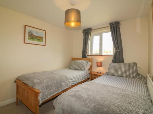 two twin beds in a room with a window at Higher Whiddon Farm Whiddon Well in Ashburton