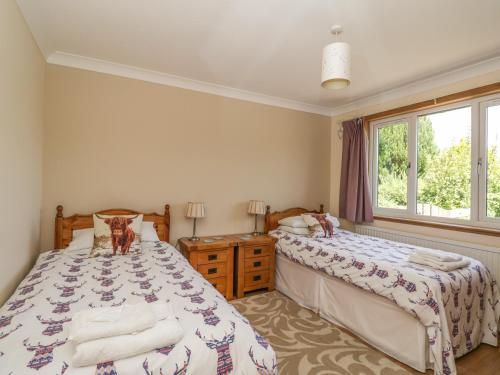 1 Schlafzimmer mit 2 Betten und einem Fenster in der Unterkunft Isla Cottage in Rattray